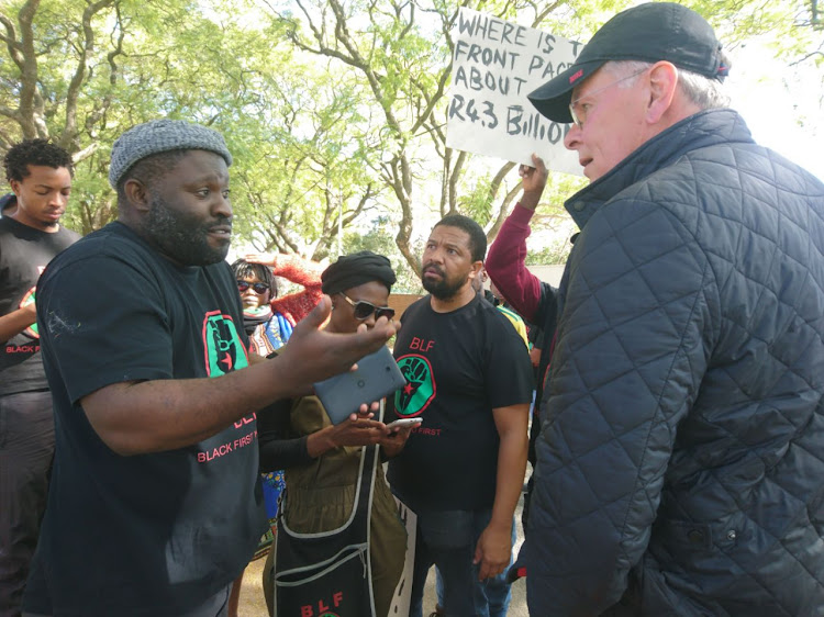 Peter Bruce confronts the protesters outside his home.