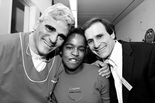 Smile Foundation co-founders Professor George Psaras, left, and chairman Marc Lubner, right, with Glenda, who received free facial reconstructive surgery in 2008.