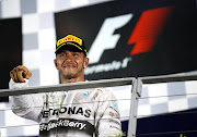 Winner Mercedes Formula One driver Lewis Hamilton of Britain gestures during the podium ceremony following the Singapore F1 Grand Prix at the Marina Bay street circuit in Singapore September 21, 2014.  REUTERS/Xavier Galiana (SINGAPORE - Tags: SPORT MOTORSPORT F1)