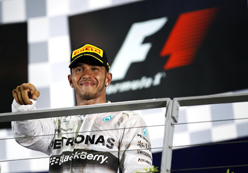 Winner Mercedes Formula One driver Lewis Hamilton of Britain gestures during the podium ceremony following the Singapore F1 Grand Prix at the Marina Bay street circuit in Singapore September 21, 2014. REUTERS/Xavier Galiana (SINGAPORE - Tags: SPORT MOTORSPORT F1)