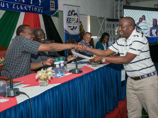 President Uhuru Kenyatta hands over a peace pledge he signed to Polycarp Igathe The vice Chair of MKenya Daima campaign during The 2nd National Leadership Summit held at Leisure Lodge Beach and Golf Resort in Kwale County.Photo PSCU