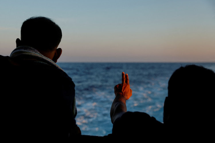 A migrant gestures on a wooden boat in international waters off the coast of Libya in the central Mediterranean Sea, September 30 2023. Picture: REUTERS/Darrin Zammit Lupi