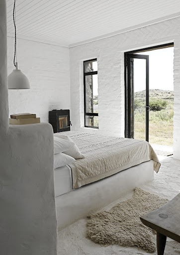 A fireplace keeps nights cosy in this serene bedroom which has a scenic view.