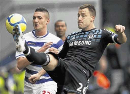 CALM IN STORM: Chelsea captain John Terry, right, clears the ball from Queens Park Rangers's Federico Macheda during their FA Cup match at Loftus Road in London on Saturday.Photo: REUTERS