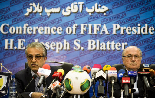 A file photo of Asian Football Confederation (AFC) president Sheikh Salman bin Ebrahim al-Khalifa of Bahrain (L) and FIFA president Sepp Blatter (R) at a press conference in Tehran on November 7, 2013. AFP PHOTO/BEHROUZ MEHRI