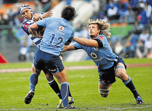 Western Province fullback Gio Aplon is tackled by Blue Bulls defenders Francois Venter, No12, and right Jacques du Plessis at Newlands