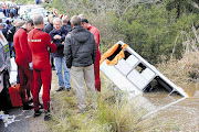Rescuers survey the grim scene after 14 children and their driver died when an overloaded school bus crashed into a river in Rheenendal, just outside Knysna in 2011.