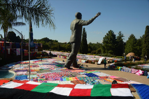 Volunteers spread blankets on grass near the Nelson Mandela statue at the Union Building on April 20, 2015 in Pretoria, South Africa. Picture Credit: Gallo Images