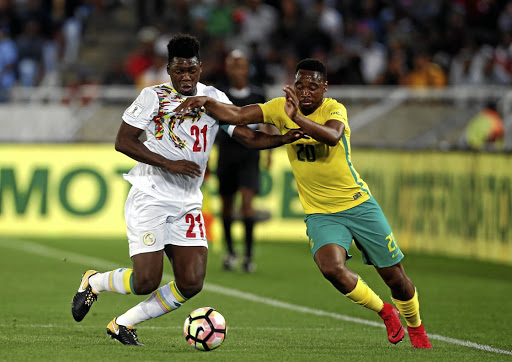 Senegal's Lamine Gassama, left, fights for the ball with Bafana Bafana's Sibusiso Vilakazi during their Word Cup qualifier match at Peter Mokaba Stadium in Polokwane on Friday. Bafana lost 2-0 and crashed out of the 2018 football extravaganza. / Siphiwe Sibeko / Reuters