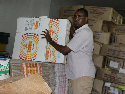 Head of Mombasa anti-counterfeit department Ibrahim Bule displays counterfeit chewing gum boxes, August 22, 2017. /MALEMBA MKONGO