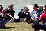 The Duke and Duchess of Sussex have fun with Waves for Change surfers at Monwabisi beach in Cape Town on September 24 2019.
