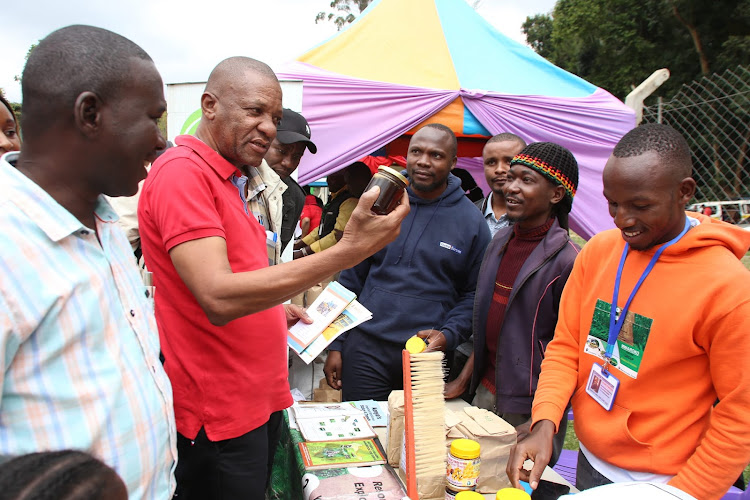 Taita Taveta Governor Andrew Mwadime samples honey from the Chawia Farmers' CBO during the International Youth Day celebrations at Wundanyi on August 12, 2023