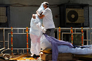 Relatives mourn a man, who died from Covid-19, next to his funeral pyre at a crematorium in New Delhi, India, on April 21 2021.