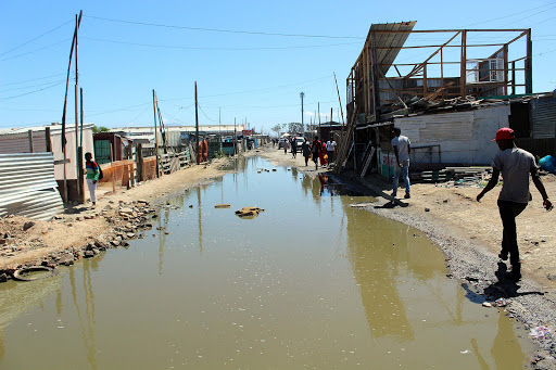 The “main road” of Marikana is a canal of stagnant water.