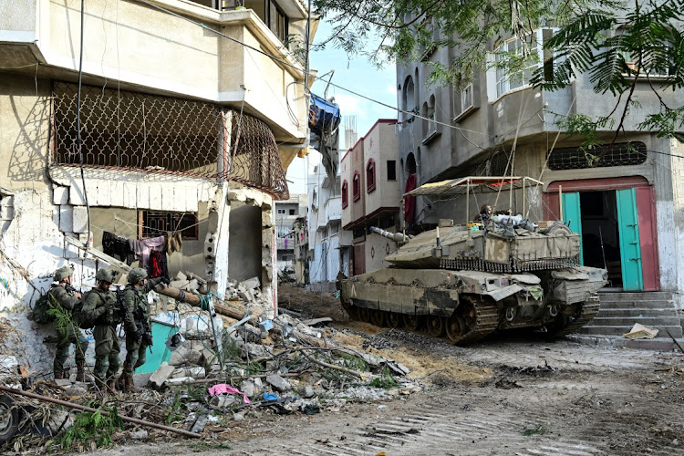 Israeli soldiers stand nearby a tank. Militant group Islamic Jihad, which is allied to Gaza’s Hamas rulers, says that its fighters are battling Israeli forces in Khan Younis, in the southern Gaza Strip. Picture: YOSSI ZELIGER/REUTERS