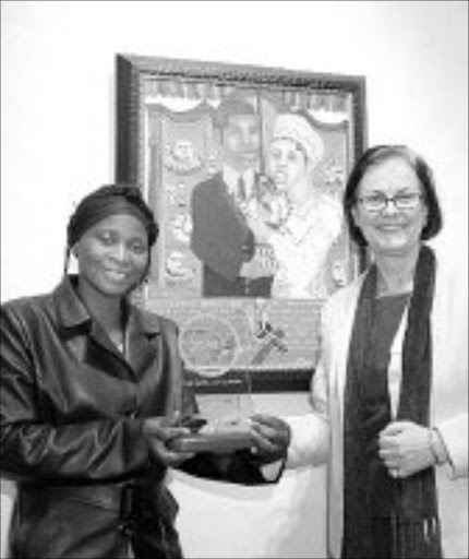 HER TIME: Lindiwe Xaba with Ann-Christin Wagenmann, the managing director of Beiersdorf, shows off her winning artwork, 'Izithandani'. © Sowetan.