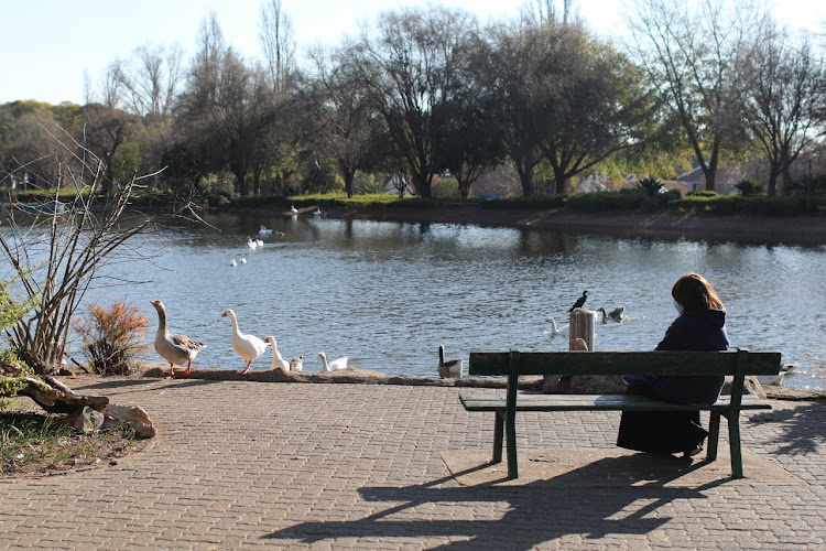 A resident sits at Zoo Lake, 29 June 2021, in Johannesburg.