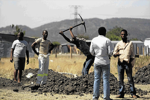 Nkaneng residents dig a grave during a site inspection by the Marikana commission of inquiry yesterday Picture: LAUREN MULLIGAN