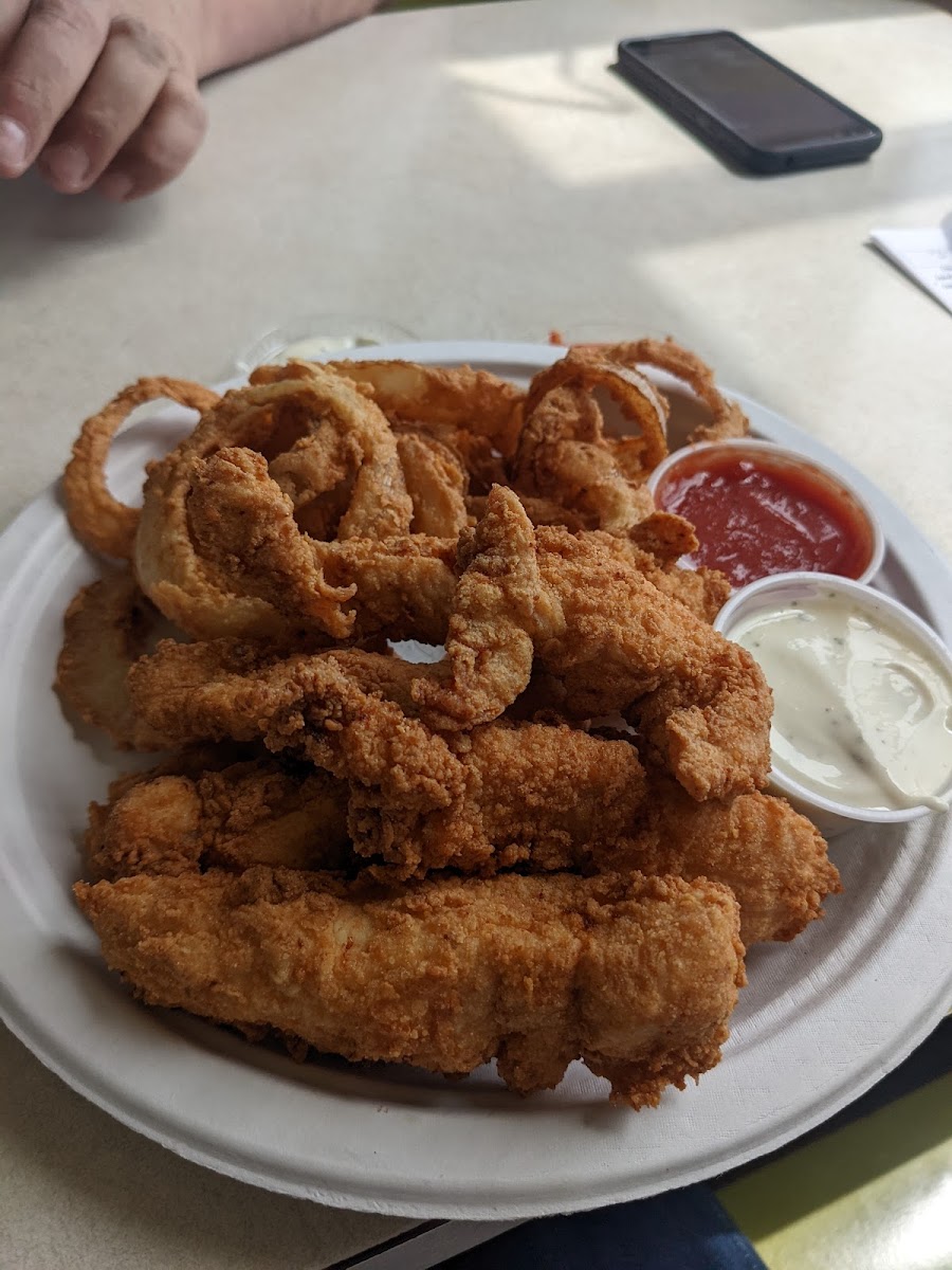 Hand-battered gluten-free chicken tenders and onion rings with side of ranch and bbq sauce
