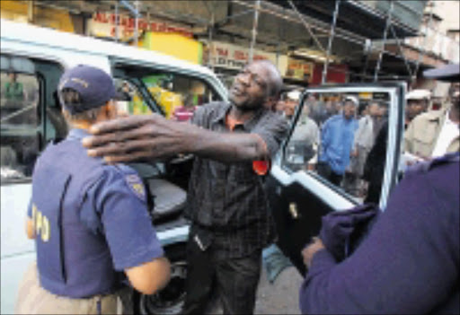 BLOCKADE: A taxi driver protests as metro police embark on Operation Nomakanjani at corner Plein and Wanderers streets in Johannesburg CBD. 16/03/09. Pic. Veli Nhlapo. © Sowetan.