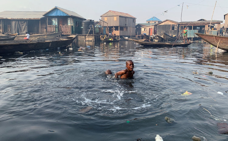 A boy swims in the polluted water of the Makoko community in Lagos, Nigeria. File photo