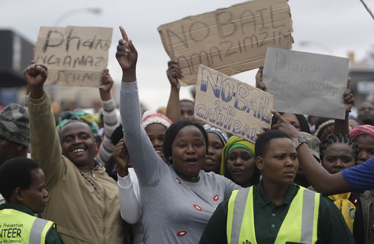 Protesters outside the Estcourt Magistrate's court on Monday, 8 August. Thursday’s crowd gathered outside the court began shouting and hurling bins when they heard that charges had been withdrawn against two of the seven men accused of cannibalism.