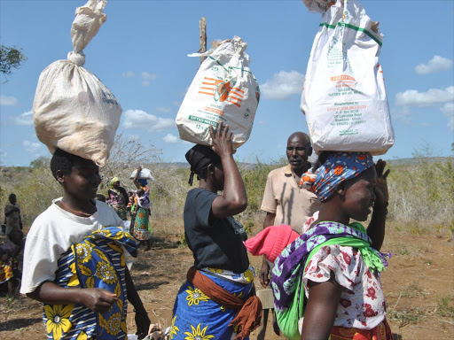 Residents of Ngamani in Ganze constituency take home relief food donated by Kilifi County Assembly on Saturday, July 22, 2016 following famine that has hit the area. /ALPHONCE GARI