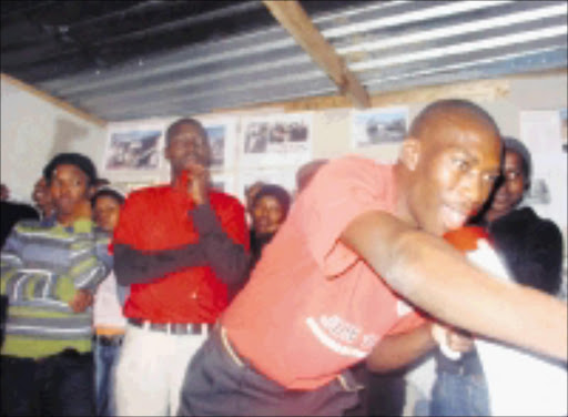 MAKING A POINT: QQ resident Mnikelo Ndabankulu speaks during a Khayelitsha shack dwellers meeting while Abahlali baseMjondolo Western Cape chairman Mzonke Poni looks on. Pic. Anna Majavu. 06/07/08. © Sowetan.