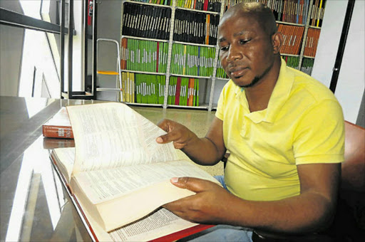 UMLUNGU: Zola Wababa, director of the University of Fort Hare IsiXhosa National Lexicography Unit, pages through and finds the word ‘umlungu’ in his unit’s definitive Greater Dictionary of IsiXhosa. Picture: MIKE LOEWE