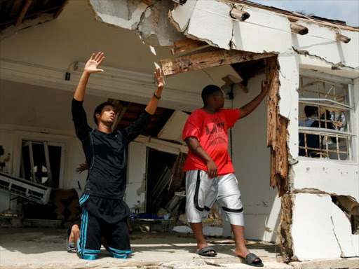 Members of the United Fellowship Ministries International Church hold an impromptu prayer service in the destroyed remains of their church in the aftermath of Hurricane Matthew in South Beach near Nassau, Bahamas October 7, 2016. /REUTERS