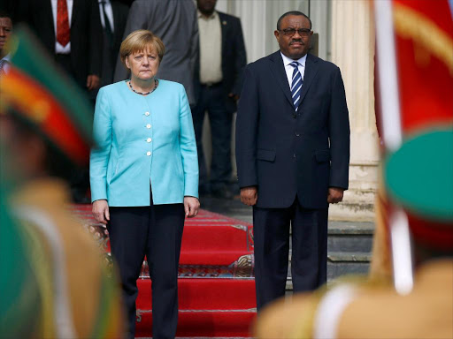 Ethiopian Prime Minister Hailemariam Desalegn (L) and German Chancellor Angela Merkel (R) listen to their national anthems at the National Palace in Ethiopia's capital Addis Ababa October 11, 2016. /REUTERS