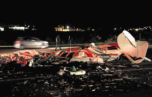 A policeman inspects the wreckage of a Cessna plane that crashed on the R55 near Centurion last night - killing the pilot and a passenger. Four men who were travelling in a Mazda 323 narrowly escaped death when the ill-fated plane struck their car as it came down lSee Story on Page 5 Picture: LAUREN MULLGAN