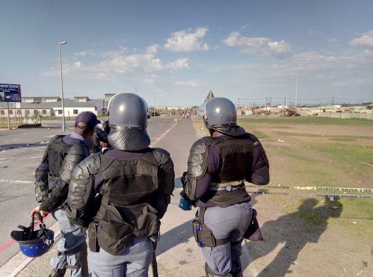 Police man a checkpoint in the coastal town of Hermanus to prevent residents gathering outside the local court when an alleged protest leader appeared on 19 July 2018.