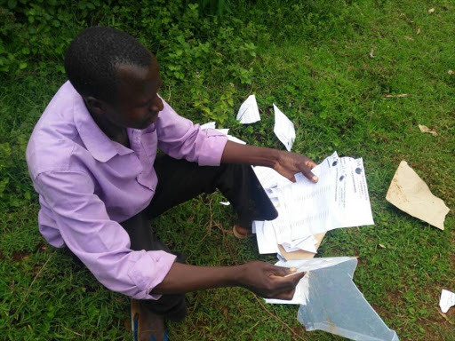 Voter Albert Nyamache inspects destroyed election materials at Bohiakumu, Kisii county, where ODM nominations began on April 20, 2017. /ANGWENYI GICHANA
