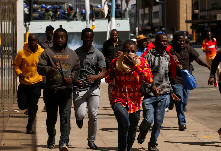 Protesters flee from teargas during clashes after police banned planned protests over austerity and rising living costs called by the opposition Movement for Democratic Change (MDC) party in Harare, Zimbabwe, August 16, 2019.