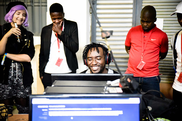 A MAZE attendees at the Tshimologong Precinct watch and play one of the featured games at the festival last year.