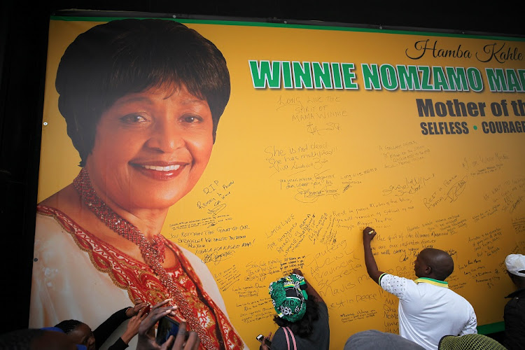 Members of the ANC write on a wall aimed to commemorate anti-Apartheid activist and struggle veteran Winnie Madikizela-Mandela outside Luthuli House in the Johannesburg CBD.