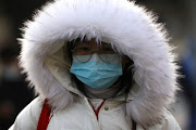 A woman wearing a protective face mask walks on a street during morning rush hour, as the coronavirus disease (Covid-19) pandemic continues in the country, in Beijing, China January 18, 2022. 