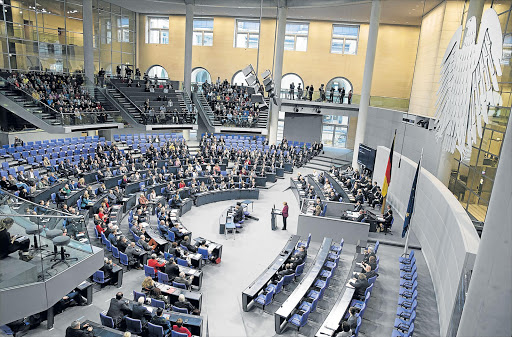 ALL EARS: German Chancellor Angela Merkel speaks in the assembly room in the German Bundestag in Berlin, Germany, yesterday. The main topic of the day was the debate on refugee policy in Germany, followed by a vote on the planned asylum law reform Picture: EPA