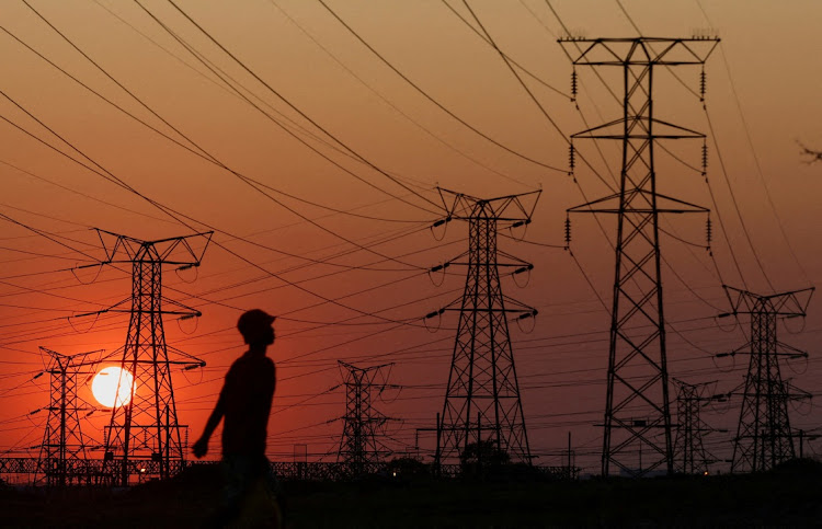 A man walks past electricity pylons in Orlando, Soweto, September 28 2022. Picture: SIPHIWE SIBEKO/REUTERS