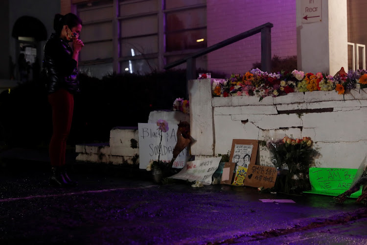 Laura Emiko Soltis, 37, holds her hands by a makeshift memorial outside of Gold Spa following the deadly shootings in Atlanta, Georgia, US March 17, 2021.