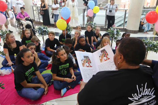 TELLING TALES: Story teller Viwe Pikolo, reads a story to children at the launch of the Department of Education and Hemingways Mall’s book garden on Saturday in East London Picture: STEPHANIE LLOYD