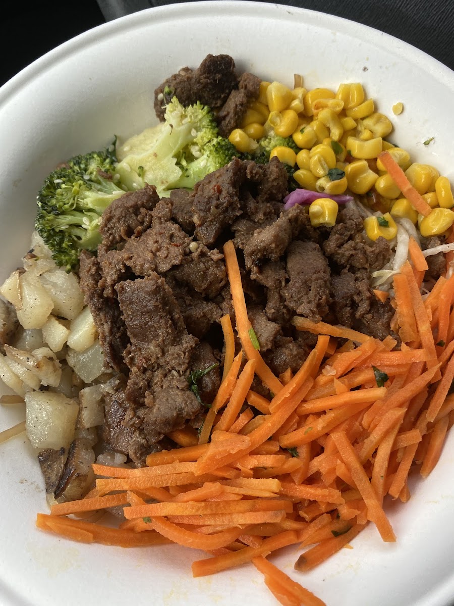 Steak bowl: sweet potato noodles, black beans, potatoes, roasted sesame broccoli, corn, carrots. Teriyaki and yum yum sauce on the side.