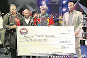 Xolisani Ndongeni, second right, receives his R1-million winner’s cheque. “Nomeva” is still waiting for his payment weeks after he scooped the big prize Picture: SINO MAJANGAZA  Picture: SINO MAJANGAZA © Daily Dispatch