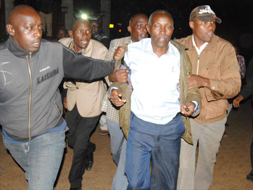 Tetu MP Ndung’u Gethenji’s chief campaigner (C) is arrested by Tetu Jubilee activists in Nyeri on Wednesday / WAMBUGU