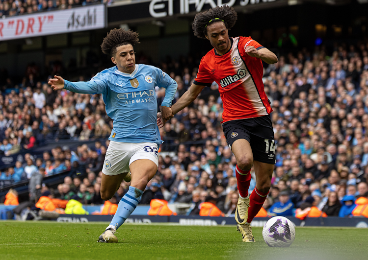 Man City's Rico Lewis (L) vies with Luton Town's Tahith Chong during the English Premier League match against Luton Town.