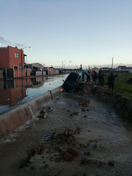 A car was sucked nose first into a sinkhole in Delft after heavy overnight rains caused flooding in Cape Town.