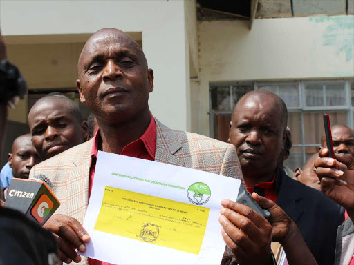ELECTION BY SONU TANU,KERICHO FEB 9TH. CAPTION KANU candidate Paul Sang displaying clearance certificate from IEBC offices in Kericho town on Tueday. KANU supporters who escorted Sang to IEBC offices in Kericho town. IEBC Commissioner Moses Sunkuli at his IEBC office in Kericho . IEBC Commissioner Mohammed Alawi his office,Kericho Pictures by Sonu Tanu. END