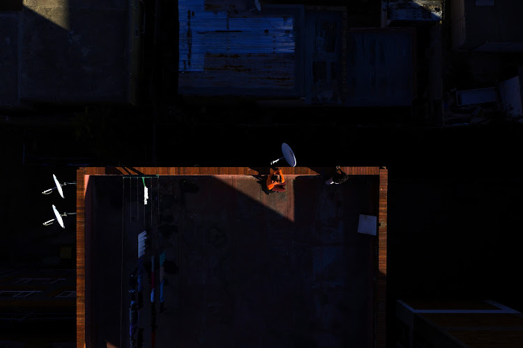 A man catches a bit of autumn sun on the rooftop of a building in Hillbrow.