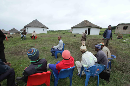 SHOCKED: Men gather outside the homestead where a bolt of lighting killed five people and injured 13 others on Saturday afternoon at the small, remote village situated near Nkanya beach on the Wild Coast near Ellliotdale Picture: LULAMILE FENI